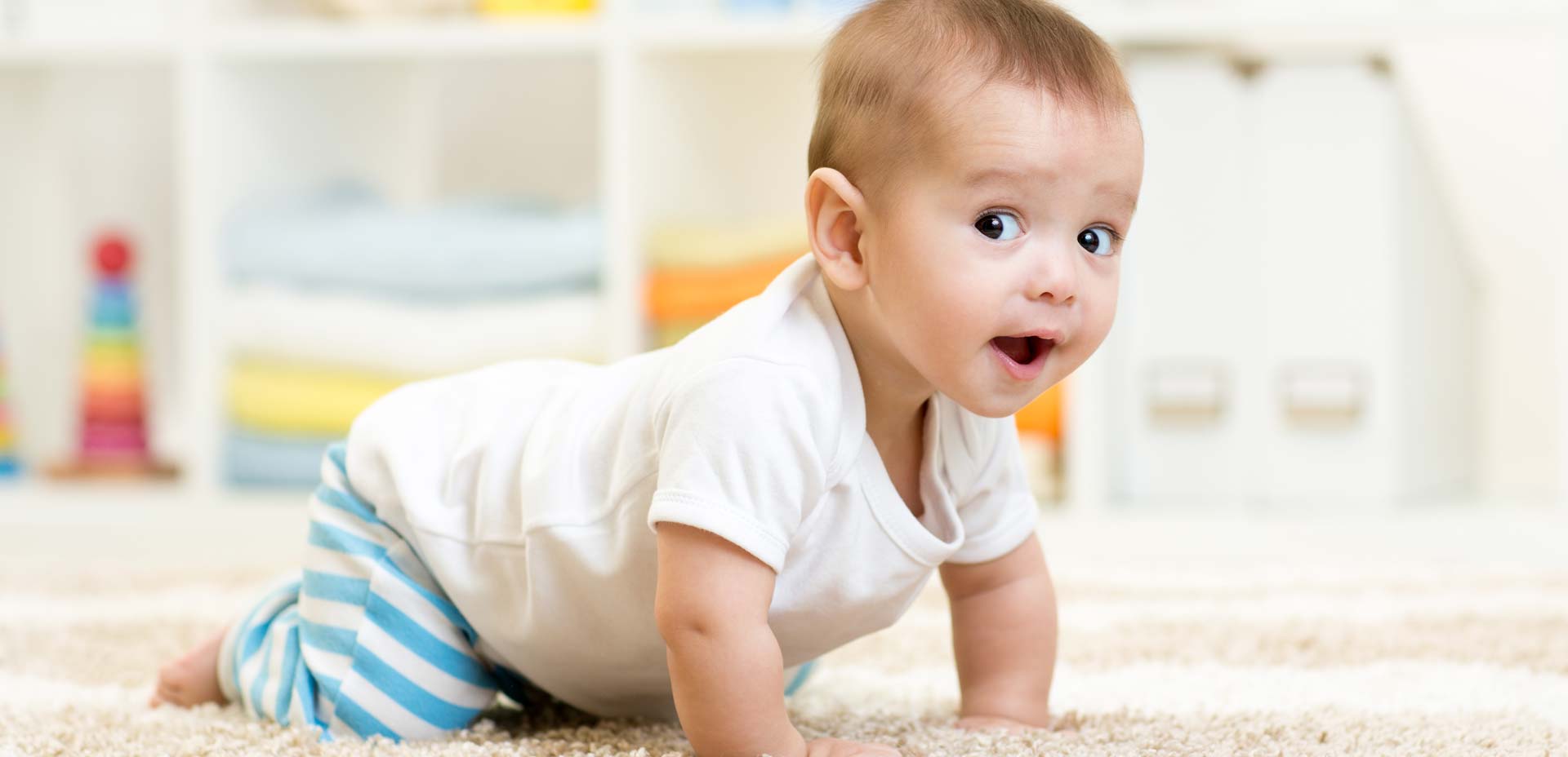Happy baby crawling on a carpet